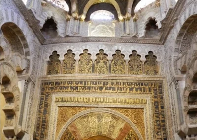 Interior del Mihrab de la Mezquita de Córdoba con cúpula dorada de mosaicos y arcos de herradura