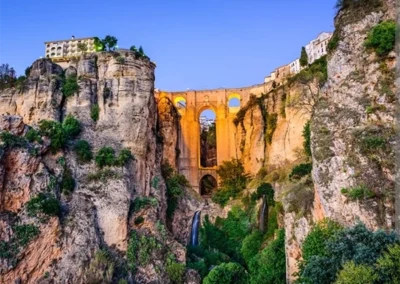 Puente Nuevo de Ronda atravesando el Tajo con edificios históricos y vegetación en el desfiladero, Málaga